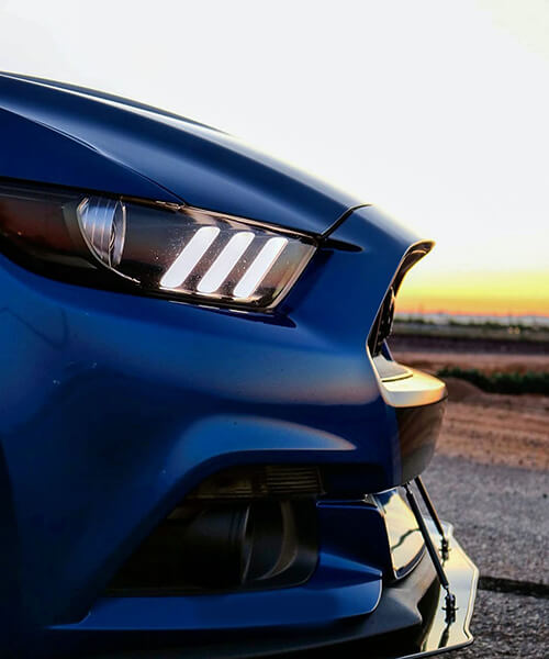 Close view of a blue car’s headlight and front bodywork