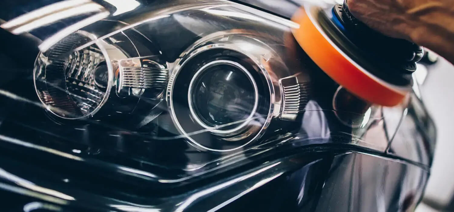 Machine polishing the outer surface of a car headlight