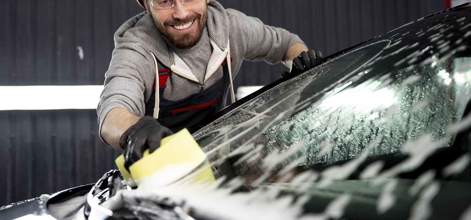 Car being washed with water and a soft wash tool