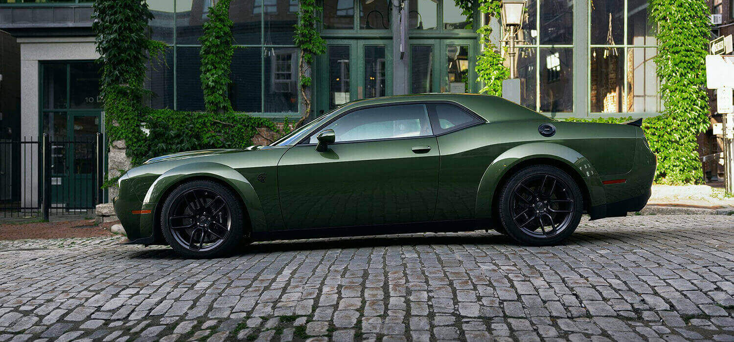 Green Dodge Challenger showing its side panels and dark wheels