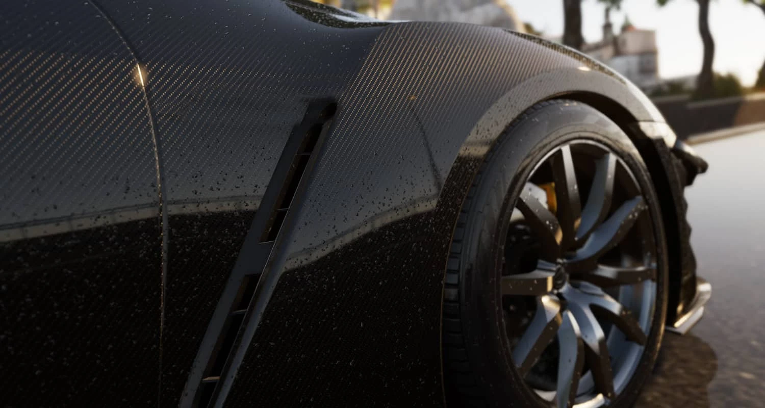 Glossy carbon-pattern appearance on a dark vehicle body panel beside a wheel