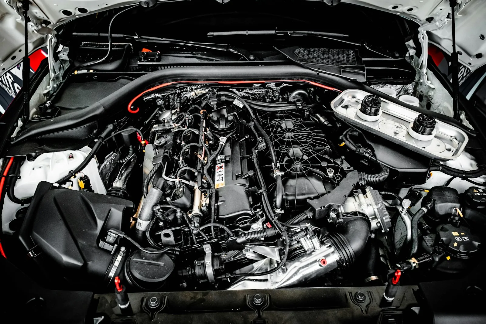 Engine compartment with exposed intake pipework and wiring