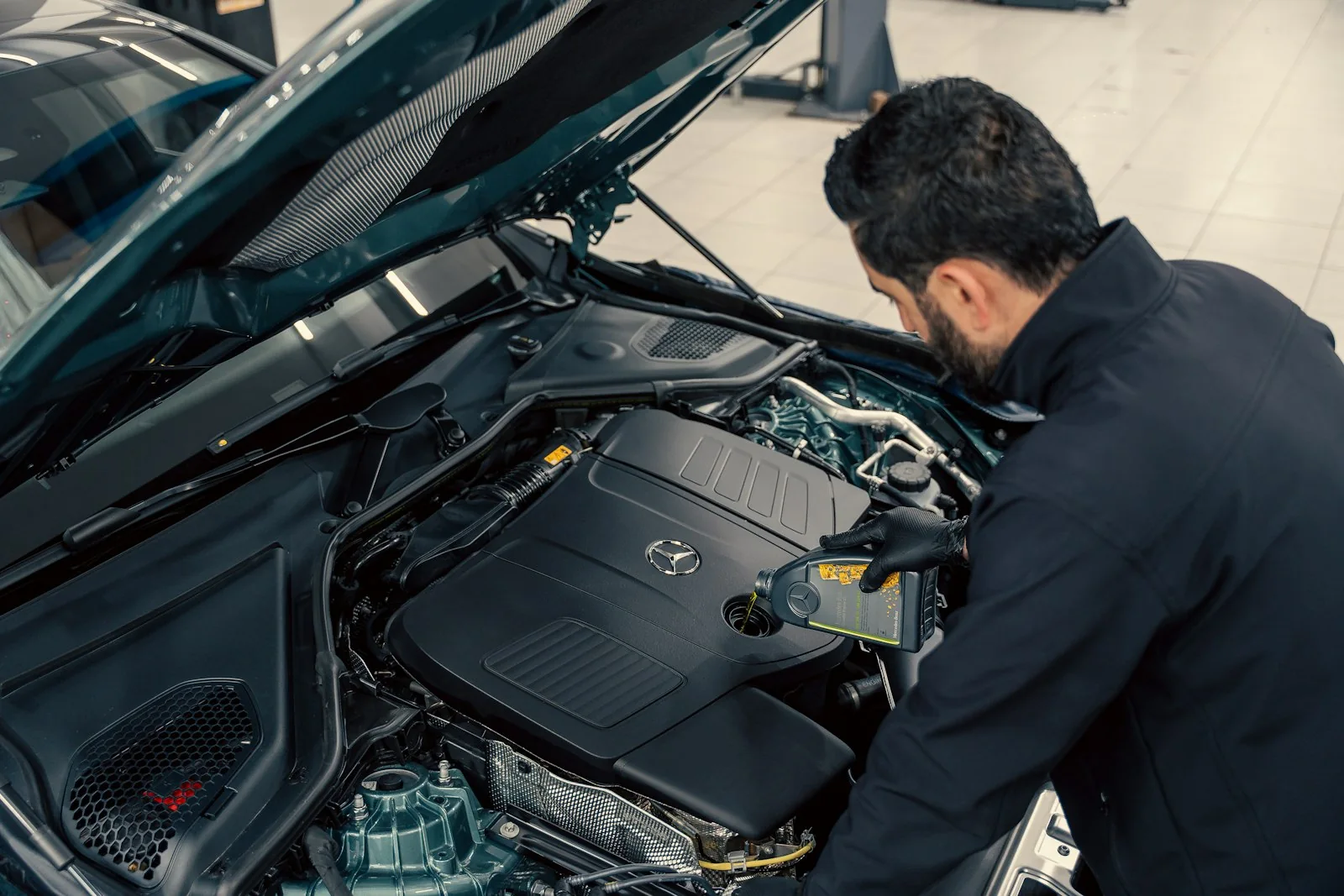 Technician inspecting beneath an open hood
