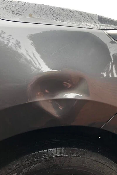 Dent in a vehicle panel above the wheel arch